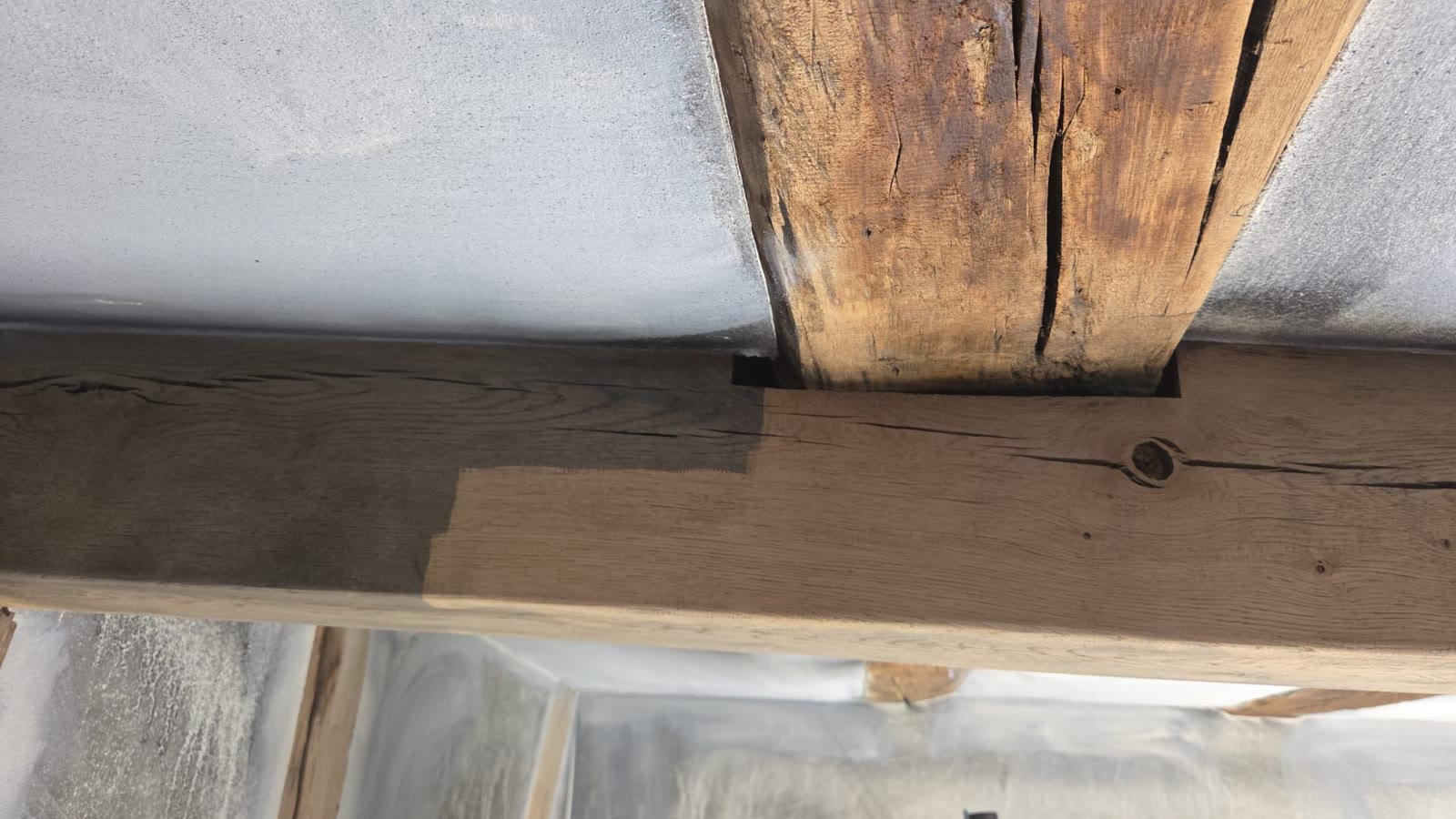 Historischer Holzbalken – ein Abschnitt bereits per Laser gereinigt, der andere im Ausgangszustand